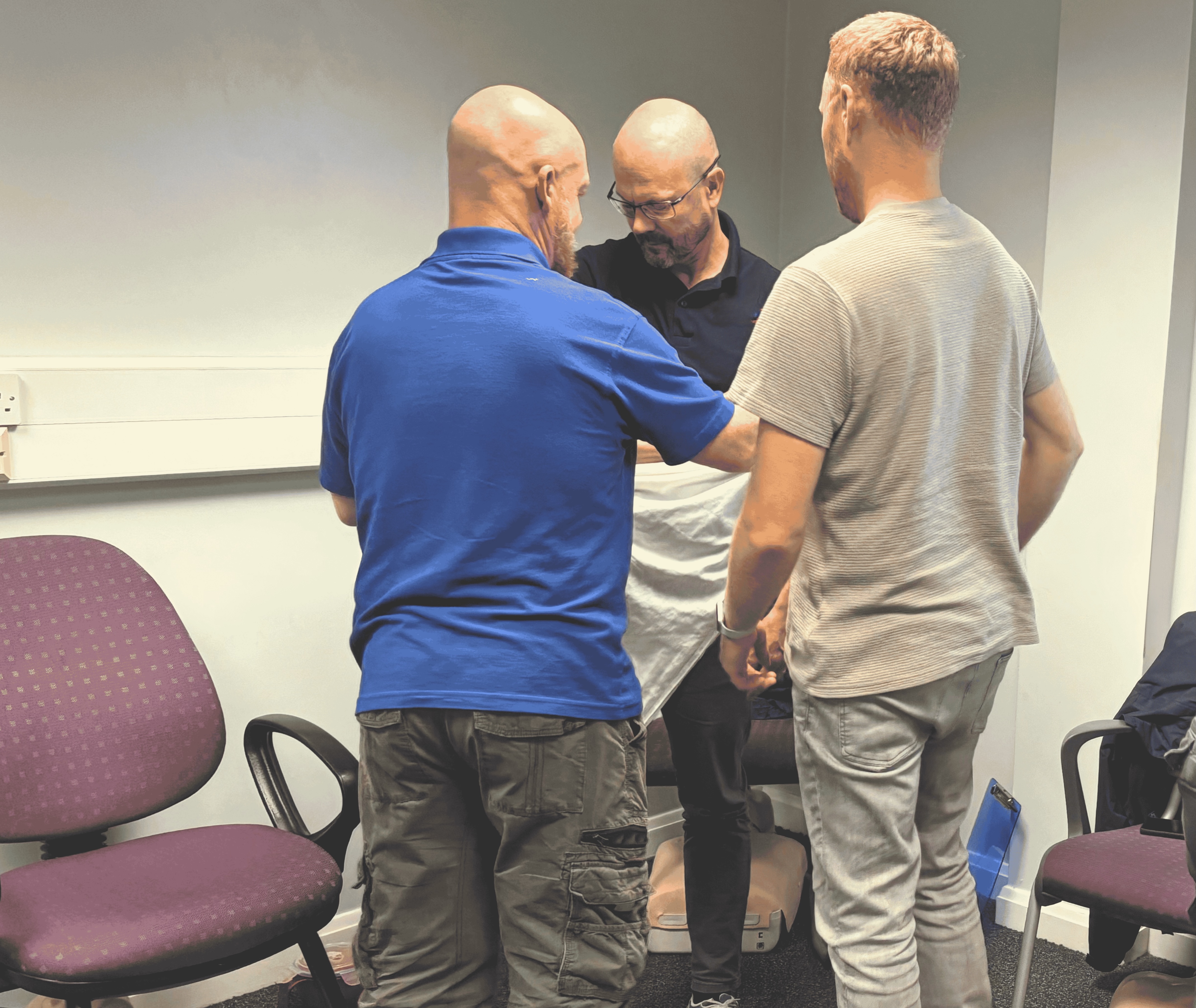 Help First Aid Training Instructor Demonstrating Correct Arm Sling Technique During First Aid Training Lead instructor Graham demonstrates the correct arm sling technique to a learner during an in-person first aid training course at Help First Aid Training.